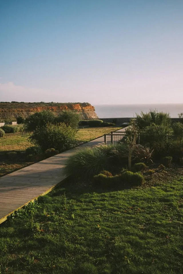 Boardwalk curving toward the Atlantic cliffs at golden hour