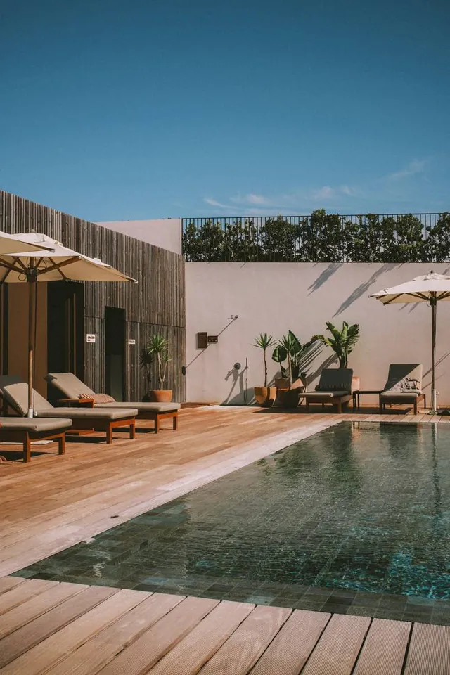 Pool terrace with teak loungers and umbrellas